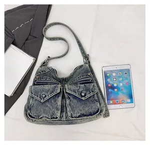 Comparaison détaillée de la taille du sac en denim bleu avec un iPad pour la capacité