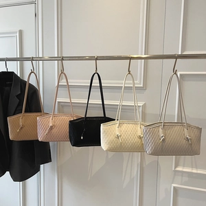 Detailed close-up of large shoulder bags showcasing unique wave pleat texture and drawstrings