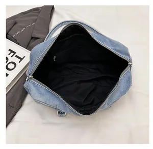 Detail view of denim tote interior featuring black lining and secure zipper pocket