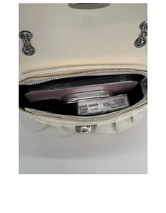 Detail shot showing the interior capacity of the cream pleated bag with chain strap