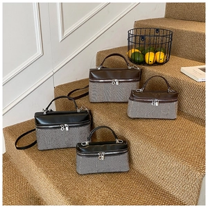 Detail view of retro herringbone weave handbags with premium leather handles on stairs