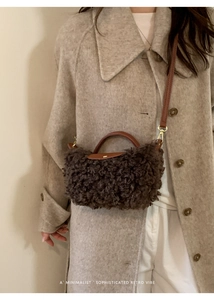 Detail of coffee brown faux fur handbag with leather flap and gold hardware