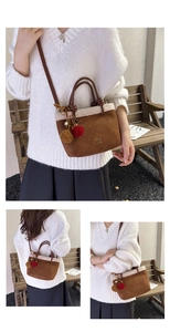 Nahaufnahme Details der braunen Wildleder Eimer Tasche mit kuscheligem Lammfell und Pompom.