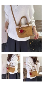 Nahaufnahme der braunen Wildleder-Beuteltasche mit Teddyfutter und Bommel-Anhängern für Herbst.