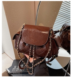Close-up of dark brown quilted oil wax leather backpack with gold chain detailing