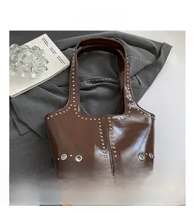 Dettaglio della borsa in pelle verniciata marrone con rivetti e borchie in metallo argento