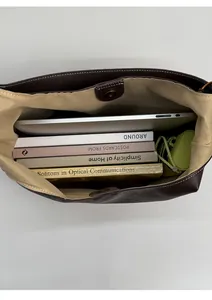 Spacious interior of a dark brown tote bag showing capacity for a laptop and books