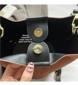 Detail of strong gold magnetic clasp on retro brown suede bucket bag with leather lining