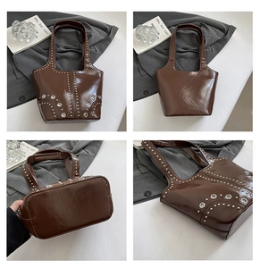 Dettagli di una borsa tote in pelle lucida marrone scuro con decorazioni di borchie argentate