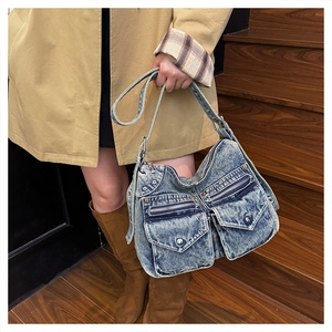 Détail du cabas en jean vintage avec plusieurs poches cargo et des ferrures argentées