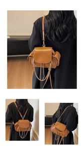 Detail of caramel brown quilted PU leather bag with metal chains and side pockets