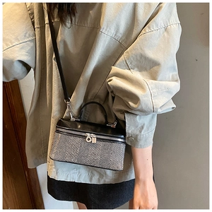 Détail du sac boîte contrasté en tissu à chevrons noir et blanc avec double fermeture éclair