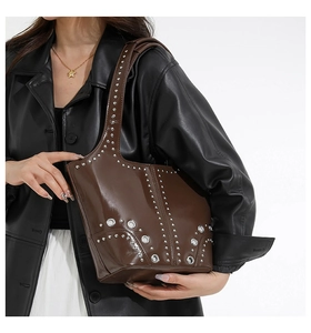 Detail of vintage brown tote bag with metallic silver rivets and punk stud elements