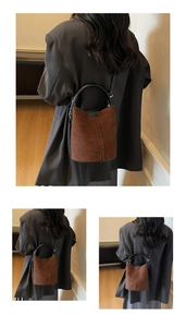 Close-up of brown suede bucket bag with vertical stitching and round black handle details