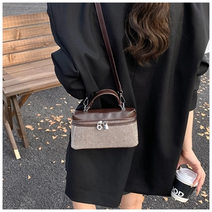 Détail du sac à bandoulière bicolore avec tissu à chevrons et fermoir anneau doré