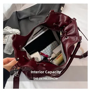Détail du grand sac seau bordeaux avec doublure rayée et fermeture par cordon serrage