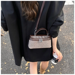 Sac à bandoulière moderne en cuir marron et tricot à chevrons présenté dans un style urbain