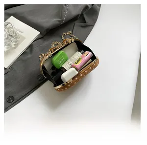 Detailed internal view showing capacity for phone and cosmetics in the polka dot chain bag