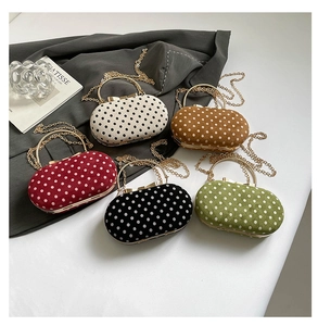 Detailed flat lay of polka dot handbags in five colors with vintage gold bow clasps
