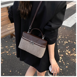 Detail of vintage patchwork crossbody bag with brown leather and herringbone fabric texture