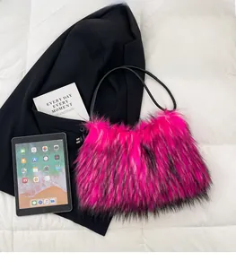 Close-up of bright pink faux fur shoulder bag with black strap on a white background