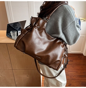 Vue latérale du sac cabas en cuir marron avec détails de cordon et boucles argentées