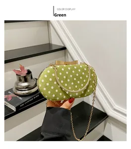 Detailed view of green polka dot evening bag with gold bow clasp and chain strap