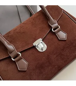 Close-up of vintage brown matte suede tote bag with silver metal twist lock closure