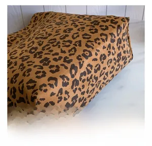 Close-up of high-quality leopard print fabric with soft faux suede texture and stitching