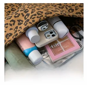 Interior view showing the large capacity of the leopard print tote bag with daily items