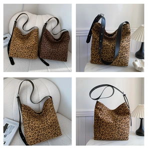 Detail of adjustable black leather strap with metal buckle on leopard print tote bag