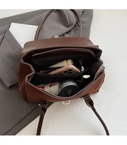 Detail view of large brown suede tote bag interior showing multiple storage compartments