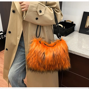 Detailed close-up of orange faux fur handbag texture with black tips and black handles