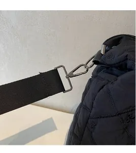 Detailed close-up of the durable metal D-ring hook on a black quilted crossbody sports bag