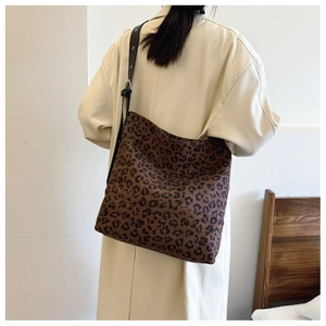 Leopard print canvas tote bag detail showing wide black strap on trench coat outfit