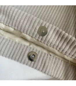 Détail macro du fermoir magnétique argenté sur sac en velours côtelé beige avec doublure