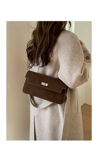 Detail view of a vintage dark brown suede shoulder bag with a silver twist lock buckle