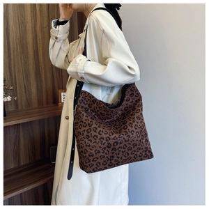 Detailed side view of large leopard print tote bag with adjustable black strap