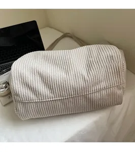 Détail du fourre-tout en velours côtelé beige montrant la texture sur un bureau