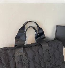 Detail of sturdy reinforced black handles and embroidered bow pattern on quilted travel bag