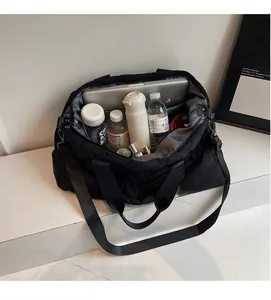 Detail shot showing the spacious interior of a black quilted travel bag with daily items