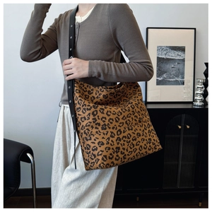 Detailed view of leopard print tote bag with wide black strap and large capacity design