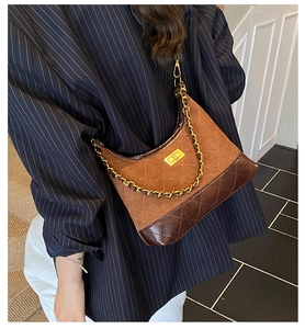 Detail of vintage quilted brown leather shoulder bag with gold twist-lock and chain strap