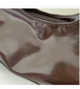 Close-up of glossy deep brown faux leather surface with a polished mirror finish