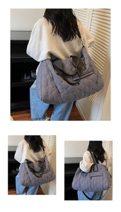 Detail view of large charcoal quilted tote bag with embroidery and adjustable strap