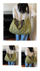 Detail of olive green quilted tote bag with black wide straps and metal zipper pocket