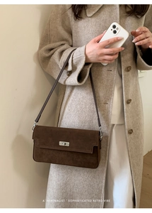 Detail view of the brown suede shoulder bag featuring a silver twist lock and slim leather strap