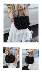 Detail of black fluffy faux fur bucket bag with smooth top handles on beige coat background