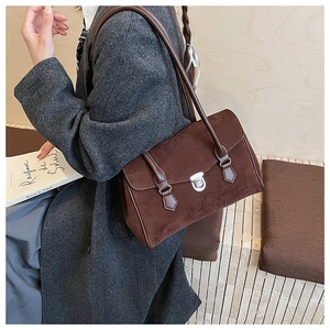 Macro detail of brown suede tote bag featuring vintage silver twist lock and leather trim