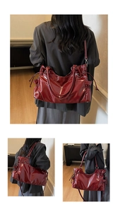 Detail of burgundy patent leather tote bag with glossy finish and drawstring accents